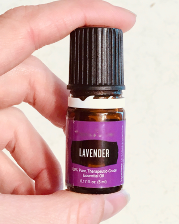 lavender essential oil bottle in a woman's hand
