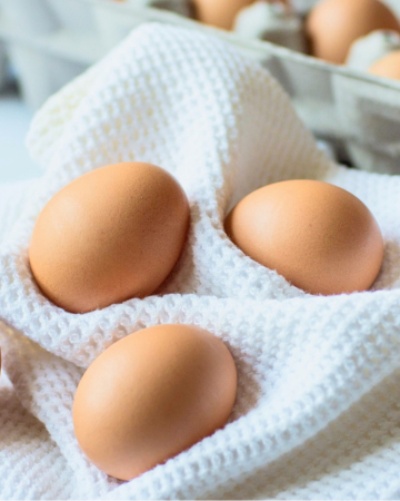 Brown eggs nestled into a white waffle towel