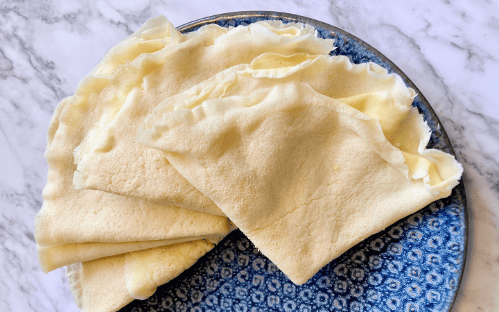 sourdough crepes fanned on a blue plate