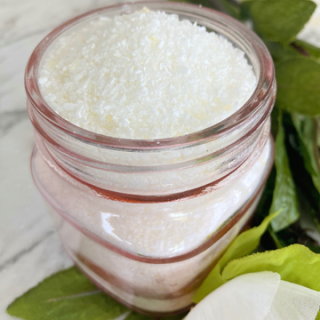 rose bath salts in a pink jar surrounded by greenery