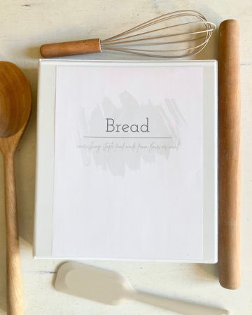 recipe organization binder framed by wooden cooking utensils
