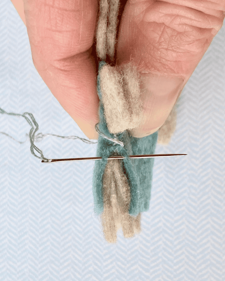 Demonstration of how to only catch the blue coverall fabric when doing the whip stitch.