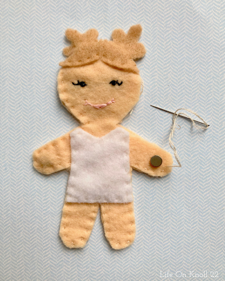 felt doll in progress with magnet placed on left hand.