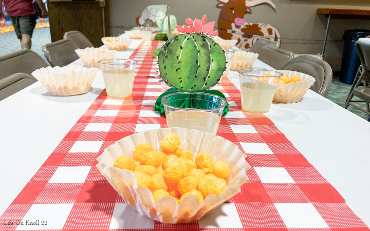 Cheeseballs in a brown coffee filter served with a hidden rolo candy and sparkling lemonade.