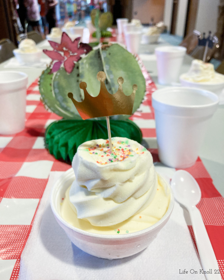 ice cream in a bowl with a crown pick and sprinkles