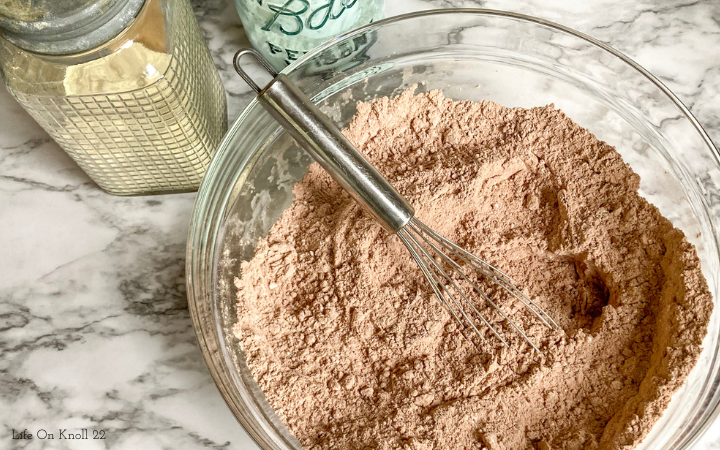 Hot chocolate mix in a glass  bowl with a whisk 