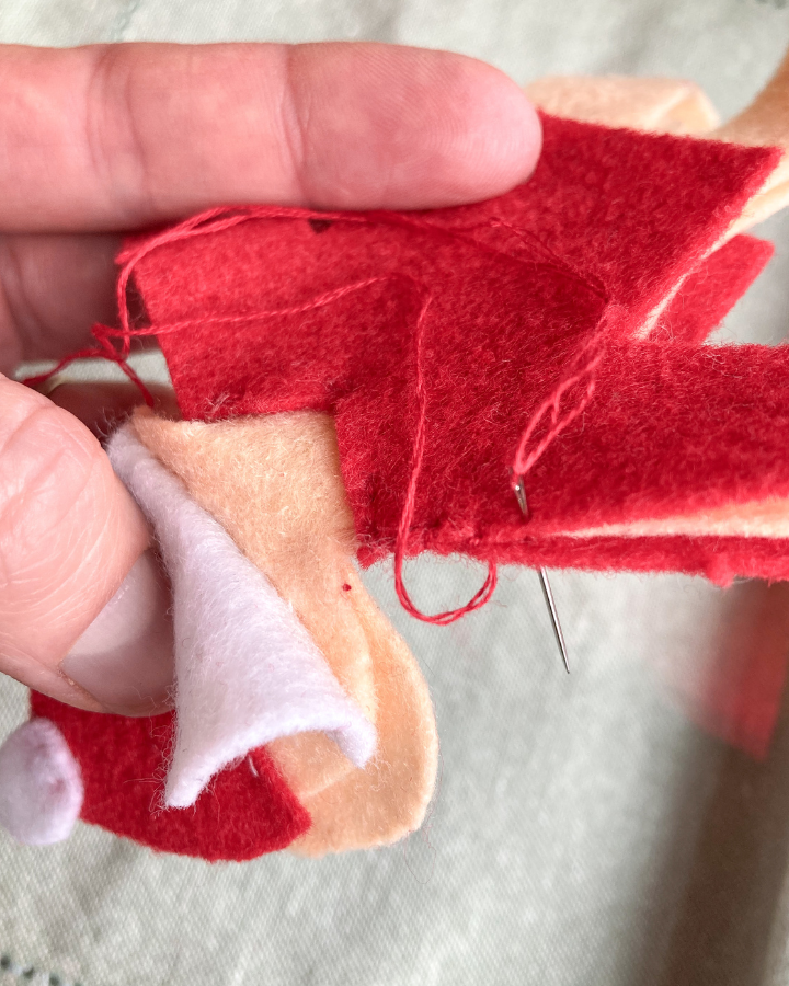 Showing how to side stitch the santa doll shirt to hide the body panel.